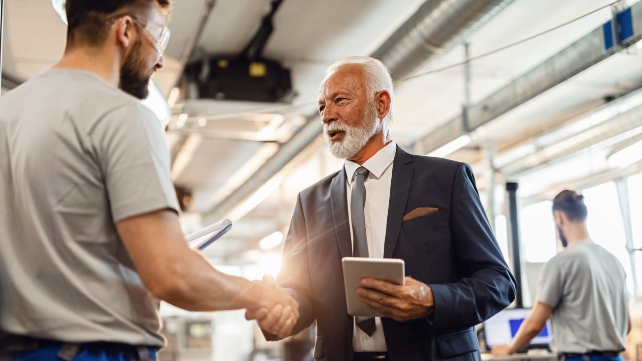 senior-businessman-handshaking-with-facility-worker-in-a-factory-e1697253105834.jpg